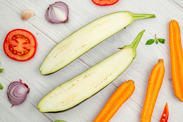 Bovenaanzicht gehakte groenten aubergine wortel tomaat op grijze houten tafel