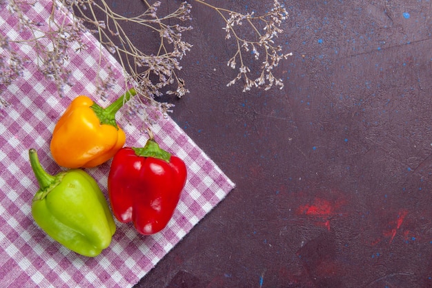 Bovenaanzicht gekleurde paprika's op grijs oppervlak plantaardige peper pittig warm eten