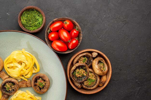 Bovenaanzicht gekookte champignons met deeg pasta op donkere tafel eten kleur van de maaltijd