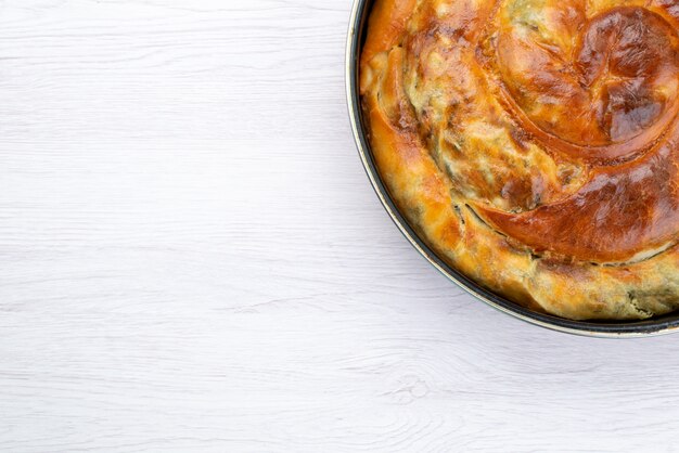 Bovenaanzicht gekookte greens gebak ronde binnen pan op de witte achtergrond bureau maaltijd eten gebak lunch greens