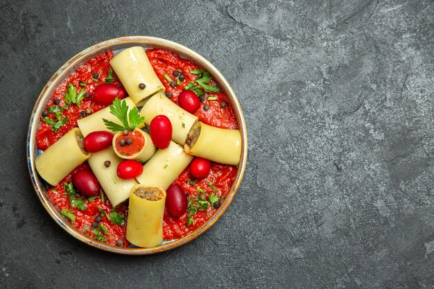 Bovenaanzicht gekookte Italiaanse pasta heerlijke maaltijd met vlees en tomatensaus op de grijze achtergrond pasta deeg vlees saus eten