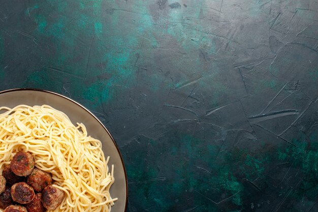 Bovenaanzicht gekookte Italiaanse pasta met gehaktballen op het donkerblauwe bureau