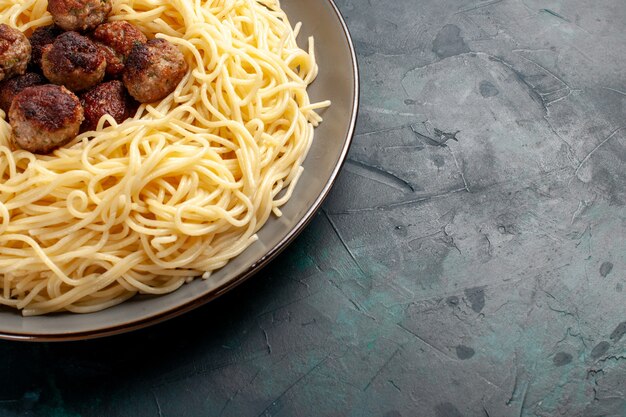Bovenaanzicht gekookte Italiaanse pasta met gehaktballen op het donkerblauwe oppervlak