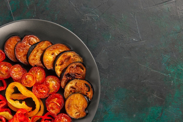 Bovenaanzicht gekookte paprika met aubergines op donkergroen oppervlak