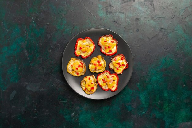 Bovenaanzicht gekookte paprika voor lunch in plaat op het donkere oppervlak