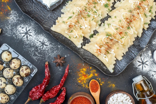 Bovenaanzicht gekookte vleesknoedels met verschillende ingrediënten op een donkere achtergrond groenteschotel koken maaltijd kleur deeg diner peper