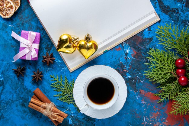 Bovenaanzicht geopend notebook dennenboom takken kegels kerstboom speelgoed op blauwe ondergrond