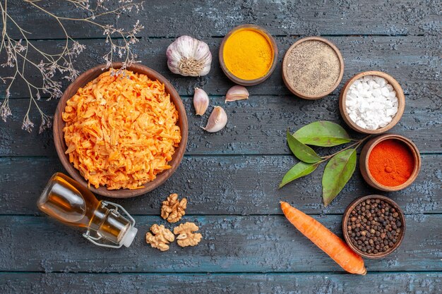 Bovenaanzicht geraspte wortelsalade met knoflook en kruiden op donkerblauw rustiek bureau gezondheid salade groenten kleur dieet rijp