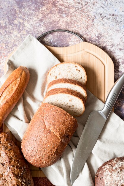 Bovenaanzicht gesneden brood met keukenpapier en mes