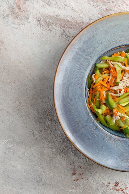 Bovenaanzicht gesneden groentesalade binnen plaat op lichte witte achtergrond