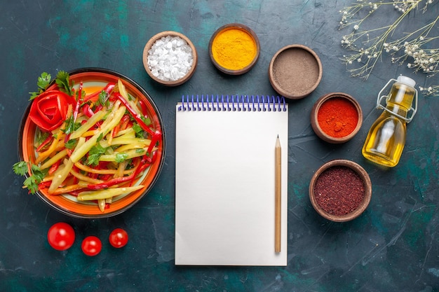 Bovenaanzicht gesneden paprika gezonde salade met verschillende kruiden op donkerblauwe achtergrond