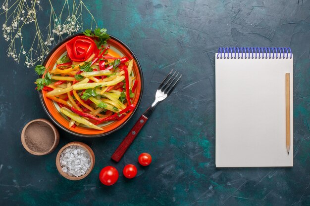 Bovenaanzicht gesneden paprika smakelijke gezonde salade met kruiden en blocnote op donkere achtergrond