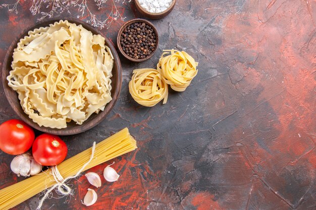 Bovenaanzicht gesneden rauw deeg op donkere ondergrond pasta deeg voedsel donker