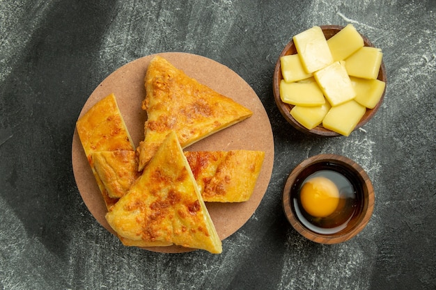 Bovenaanzicht gesneden taart met kaas op de grijze achtergrond voedsel maaltijd gebak bak oven zoet koekje