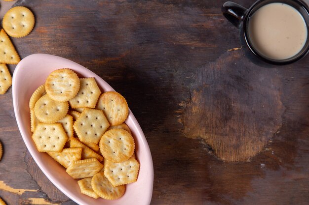 Bovenaanzicht gezouten lekkere chips met zwarte kop melk op de houten achtergrond voedsel ontbijt maaltijd snack