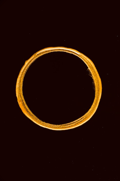 Bovenaanzicht gouden gesmolten cirkel op zwarte achtergrond