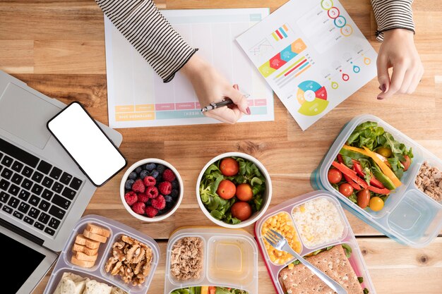 Bovenaanzicht grafieken en biologisch voedsel in lunchboxen