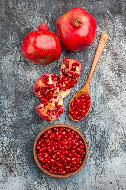 Gratis foto bovenaanzicht granaatappel twee granaatappels gepelde granaatappel lepel granaatappel zaden