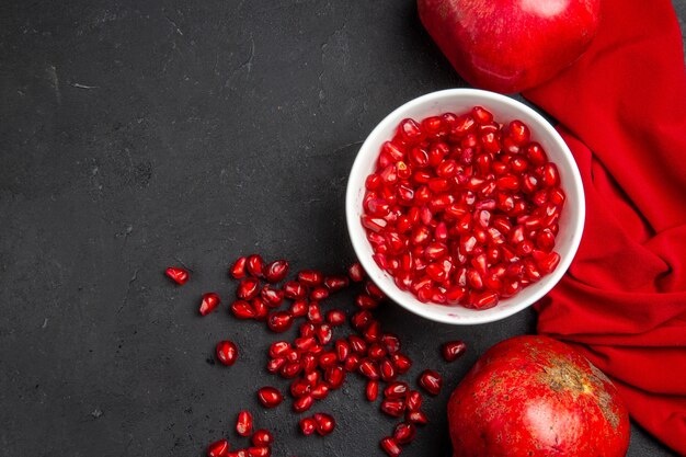 Bovenaanzicht granaatappel twee granaatappels granaatappel zaden in de kom rood tafellaken