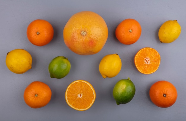 Bovenaanzicht grapefruit met sinaasappels, citroenen en limoenen (lemmetjes) op grijze achtergrond