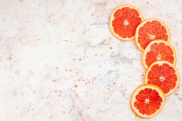 Gratis foto bovenaanzicht grapefruits plakjes op naakt oppervlak met kopie ruimte