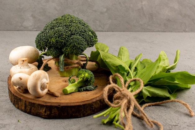 Bovenaanzicht groene broccoli vers rijp met champignons op de lichte achtergrond