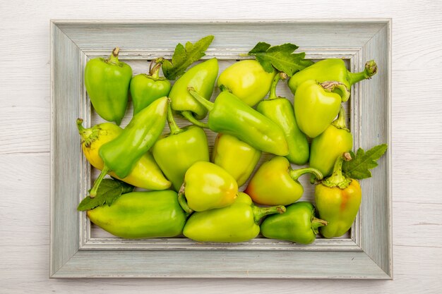 Bovenaanzicht groene paprika binnen frame op witte tafel