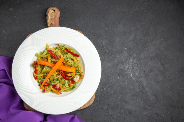 Bovenaanzicht groenten de paarse tafellaken salade op de snijplank