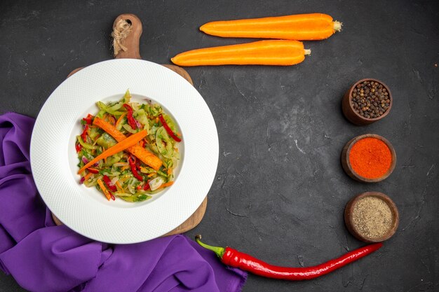 Bovenaanzicht groenten salade op de snijplank kruiden wortelen tafelkleed