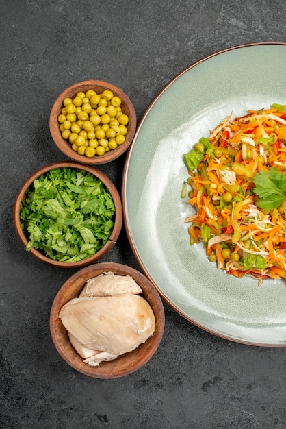 Bovenaanzicht groentesalade met ingrediënten op de grijze gezondheidssalade dieetvoeding