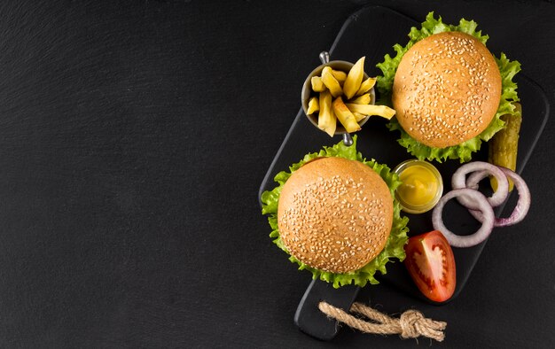 Bovenaanzicht hamburgers en frietjes met augurken en kopie-ruimte