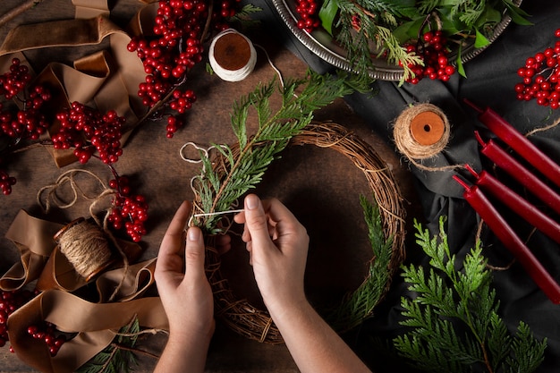 Gratis foto bovenaanzicht handen die adventskrans monteren