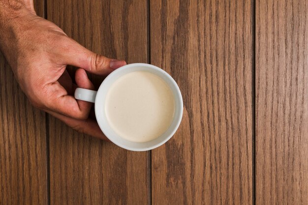 Bovenaanzicht handen met kopje koffie