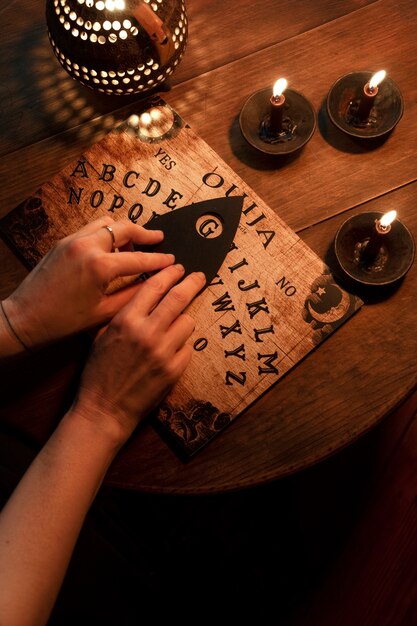 Bovenaanzicht handen op ouija bord