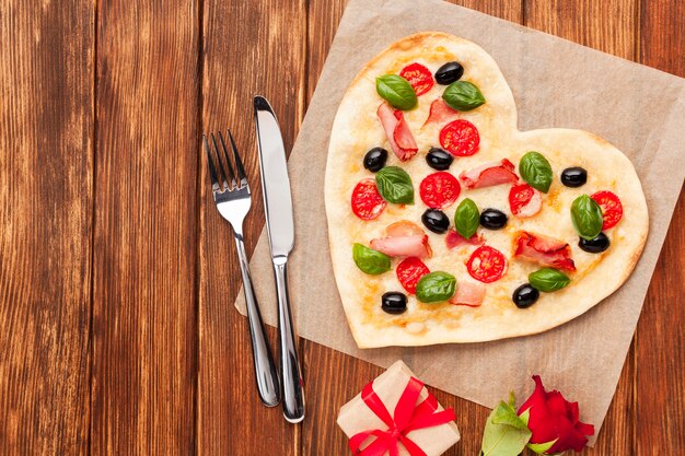 Bovenaanzicht hartvormige pizza met servies