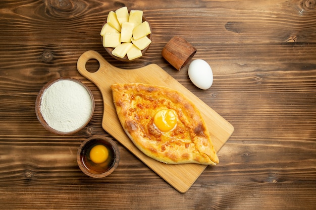 Bovenaanzicht heerlijk eierbrood gebakken op bruin houten bureau