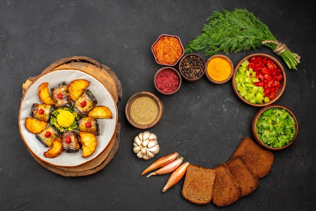 Bovenaanzicht heerlijke aubergine rolt gekookt gerecht met aardappelen en groenten op de donkere achtergrond koken voedsel schotel bak bak aardappel