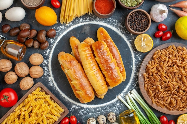 Bovenaanzicht heerlijke bagels met noten, eieren, pasta en smaakmakers op de donkere achtergrond, walnotenmaaltijd, peper, fruit, foto, kleur, voedsel