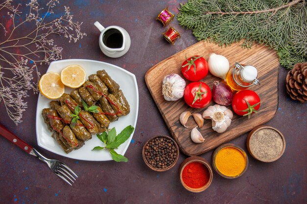 Bovenaanzicht heerlijke bladdolma met verse groenten en kruiden op de donkere achtergrond maaltijdschotel blad vlees diner eten