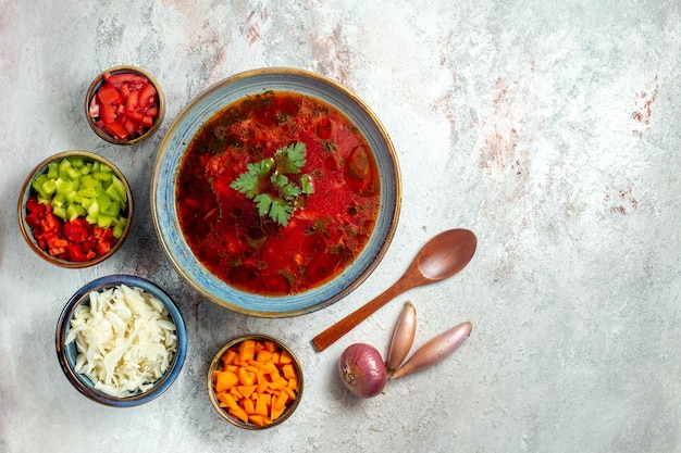 Bovenaanzicht heerlijke borsch beroemde Oekraïense bietensoep met vlees en peper op wit bureau on