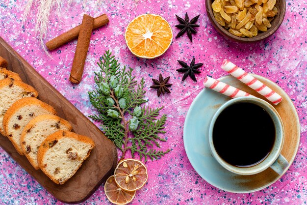 Bovenaanzicht heerlijke cake gesneden taart met rozijnen en met kopje koffie op het roze bureau Bak taart suiker zoet koekje