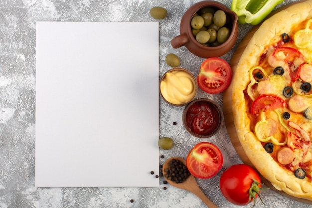 Bovenaanzicht heerlijke cheesy pizza met olijven worstjes en rode tomaten op de grijze achtergrond fastfood Italiaanse deegmaaltijd