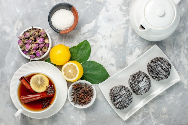 Bovenaanzicht heerlijke chocolade taarten kleine ronde gevormd met verse citroen op witte achtergrond fruit cake koekje zoete suiker bakken cookie