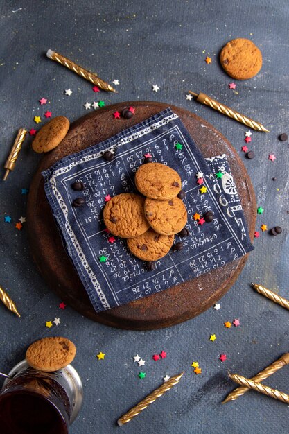 Bovenaanzicht heerlijke chocoladekoekjes met kaarsen op de donkergrijze achtergrond cookie biscuit zoete suiker