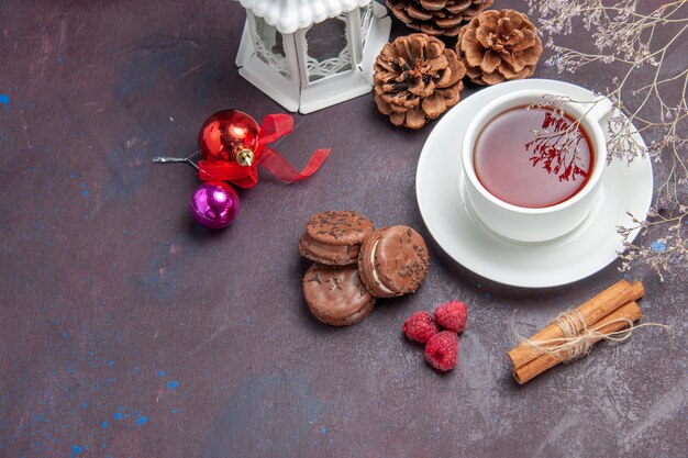 Bovenaanzicht heerlijke chocoladekoekjes met kopje thee op donkere achtergrond taartkoekje zoete cake koekjesthee