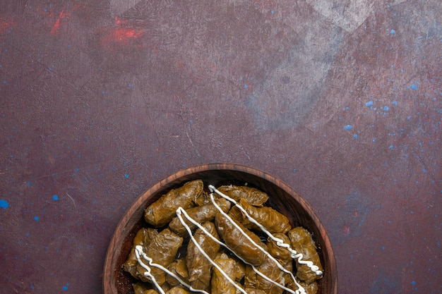 Gratis foto bovenaanzicht heerlijke dolma oosterse schotel met bladeren en gemalen vlees binnen op donkere achtergrond calorie diner vlees eten olie schotel