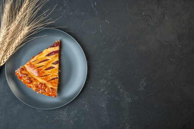 Bovenaanzicht heerlijke fruitige taart met jam in plaat op donkere tafel