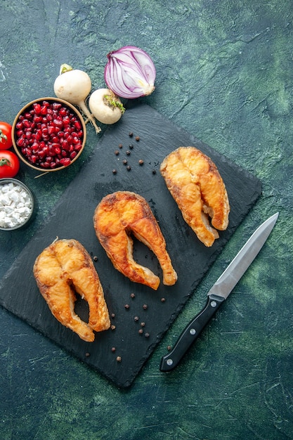 Bovenaanzicht heerlijke gebakken vis op een donkere ondergrond schotel salade zeevruchten gebakken vlees zee peper eten koken maaltijd