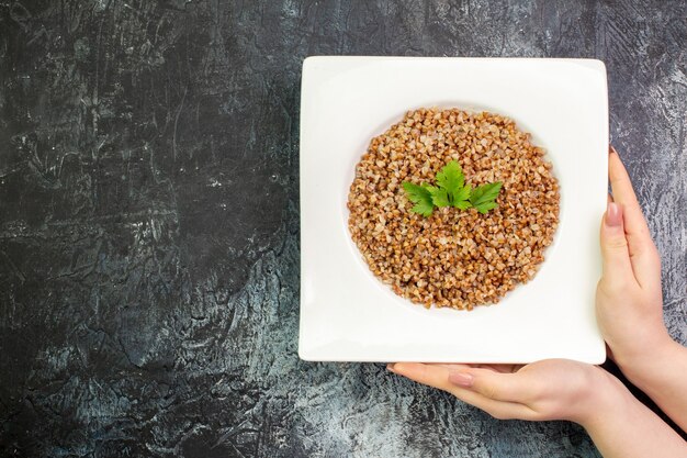 Bovenaanzicht heerlijke gekookte boekweit in plaat op lichtgrijze achtergrond calorie voedsel maaltijd kleur foto gerecht bean