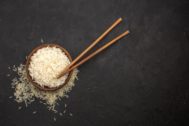 Bovenaanzicht heerlijke gekookte rijst smakelijke oosterse maaltijd op donkere ruimte